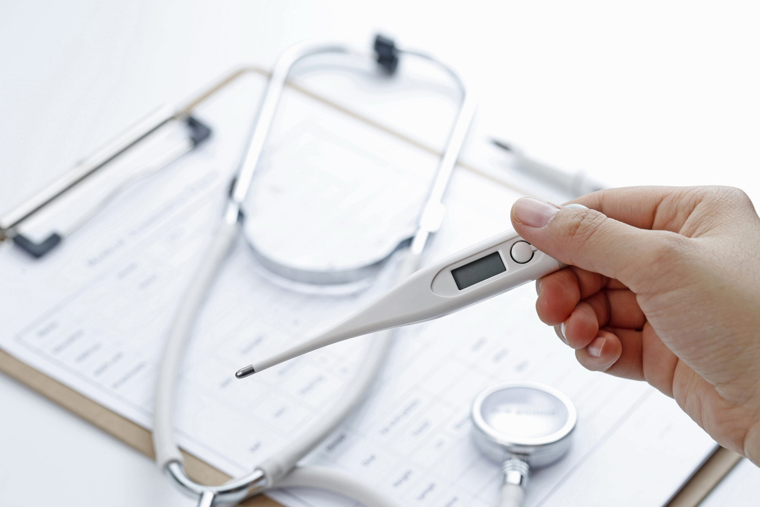 врач держит электронный градусник